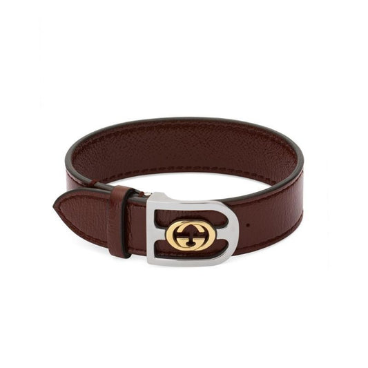 A burgundy leather bracelet with a silver and gold interlocking G logo design buckle.