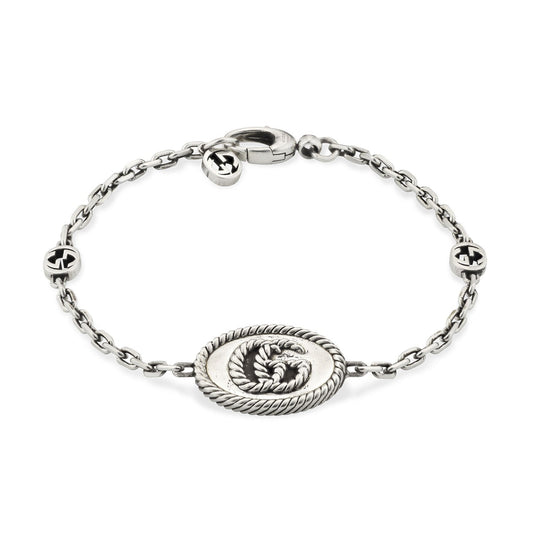 A Gucci sterling silver chain bracelet from GUCCI Fine Jewellery, featuring an interlocking G pendant in the center and accented by two round motifs with the iconic Double G design. It is secured with a simple lobster claw clasp.