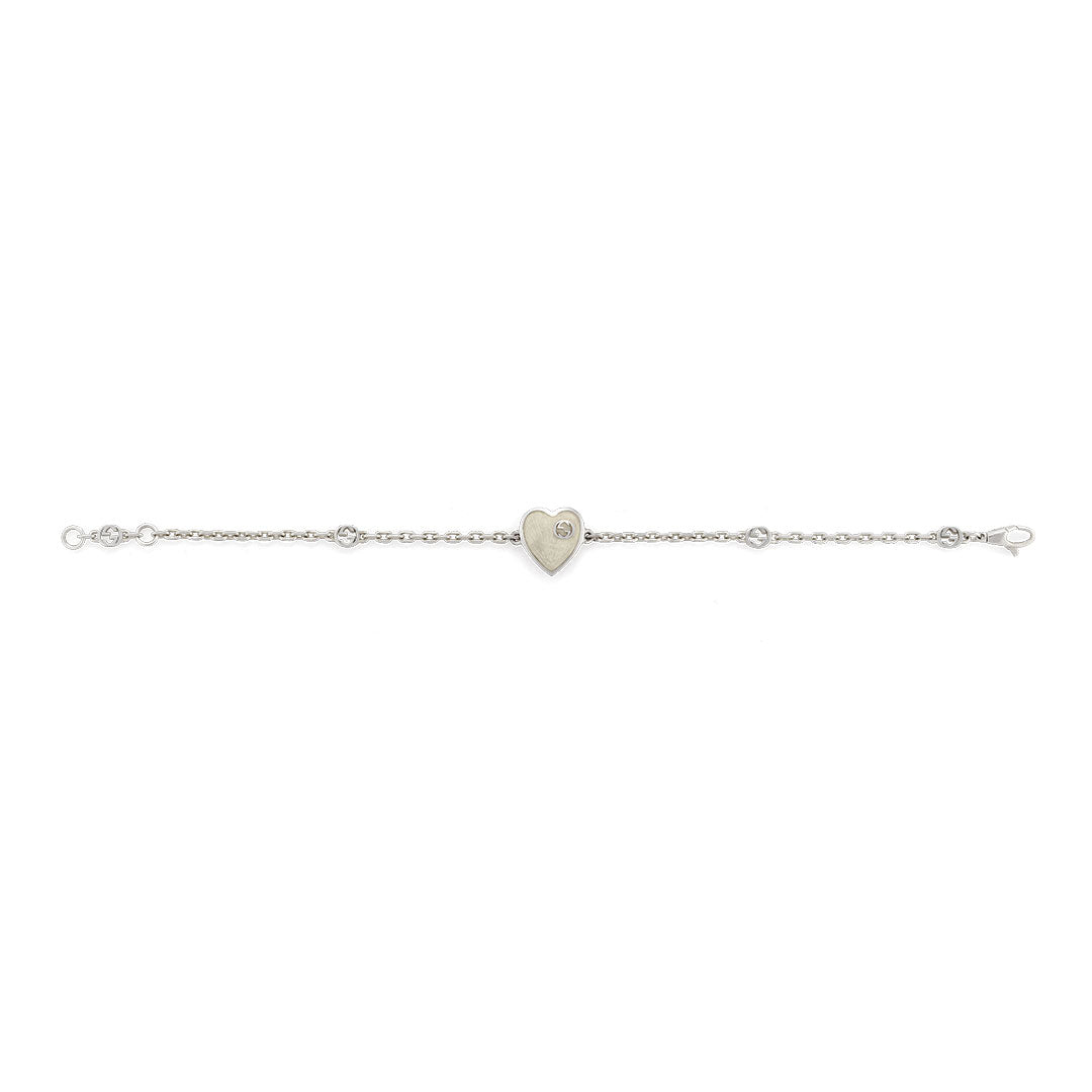The Gucci Interlocking G Heart Enamel Sterling Silver Bracelet by GUCCI Fine Jewellery features a heart charm with a central stone and a fine chain with delicate decorative links.