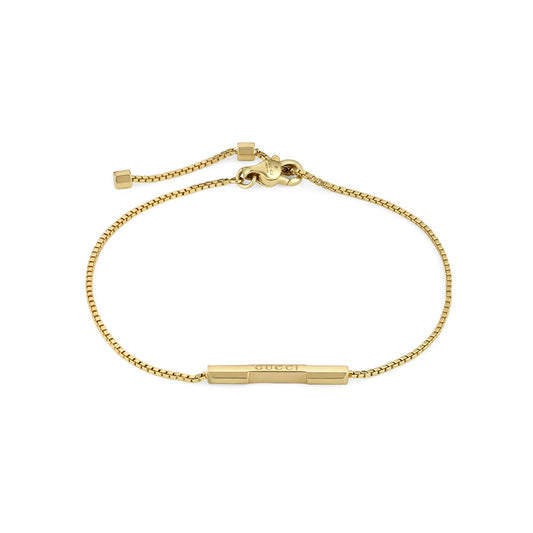 The Gucci Link to Love 18K Yellow Gold Chain Bracelet with "Gucci" Bar by GUCCI Fine Jewellery is crafted in yellow gold and features a sleek bar engraved with the iconic "Gucci" logo. It is designed with an adjustable sliding clasp for a customizable fit, embodying minimalist elegance.