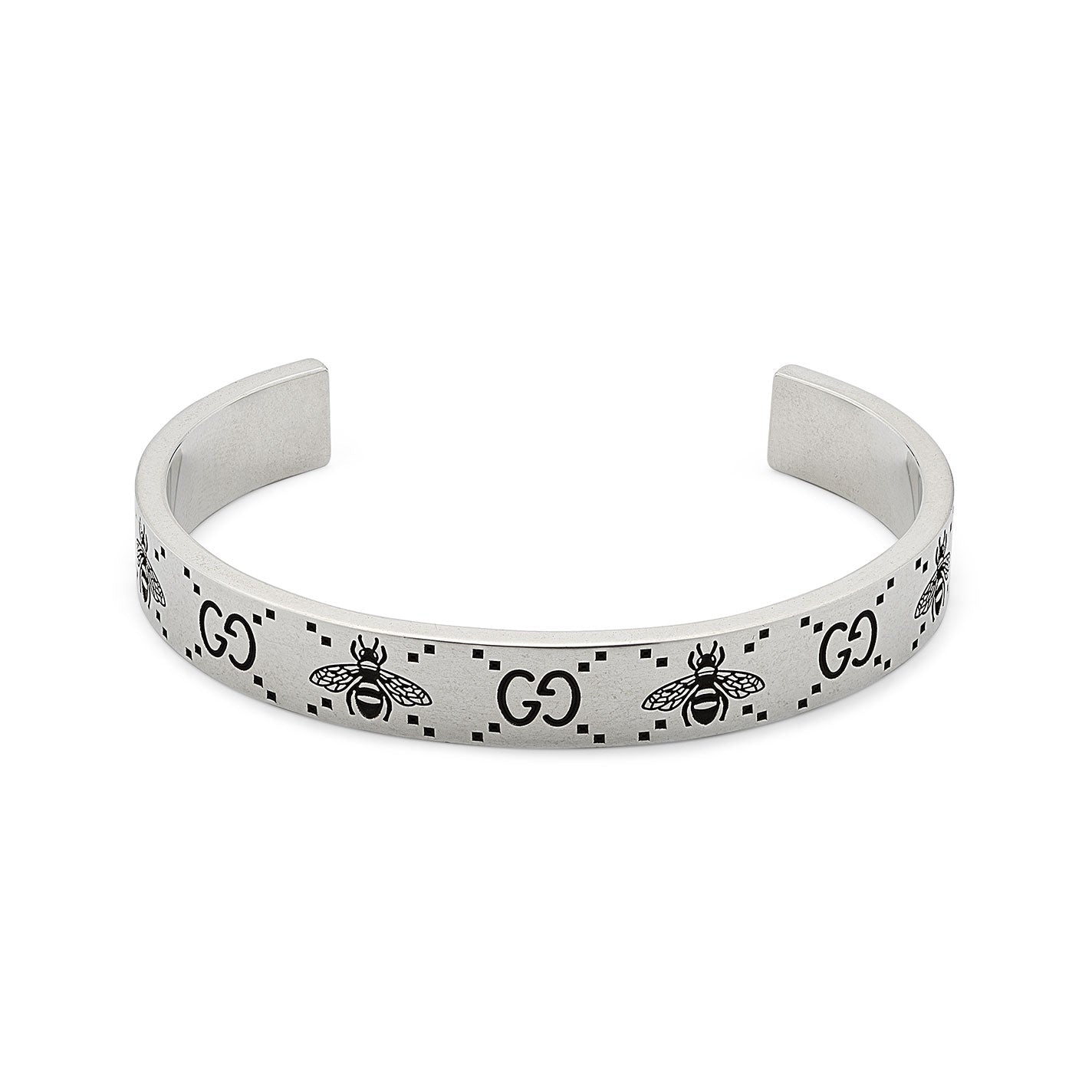 The Gucci GG And Bee Engraved Sterling Silver Cuff Bracelet from GUCCI Fine Jewellery showcases detailed bee engravings and prominent "GG" motifs, beautifully arranged upright against a clean white backdrop.