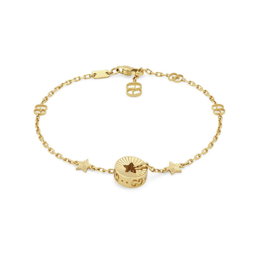 Introducing the Gucci Icon Star 18K Yellow Gold Station Bracelet from GUCCI Fine Jewellery. This stunning bracelet showcases a charm featuring a flower motif with star accents, elegantly set on a fine chain. It includes a decorative clasp and small cut-out circle designs, making it an exquisite addition to any ensemble.