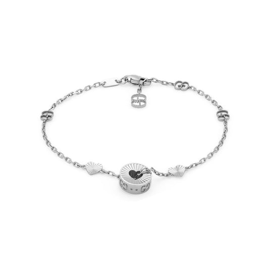 The Gucci Icon 18K White Gold Heart Bracelet from GUCCI Fine Jewellery is crafted with a delicate chain adorned with the iconic GG motif and features several small, decorative charms in round and fan-shaped designs. Made under Responsible Jewellery Council standards, this sleek, modern piece in 18k white gold includes a secure lobster clasp closure.