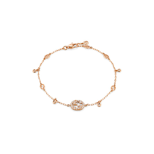 The Gucci Interlocking 18K Rose Gold Diamond Bracelet from GUCCI Fine Jewellery showcases a central circular charm adorned with small diamonds, echoing the elegance of the Gucci Interlocking design. This bracelet includes an adjustable lobster clasp closure and features additional small circular charms along its length, reflecting the charm of GG Pavé rings.