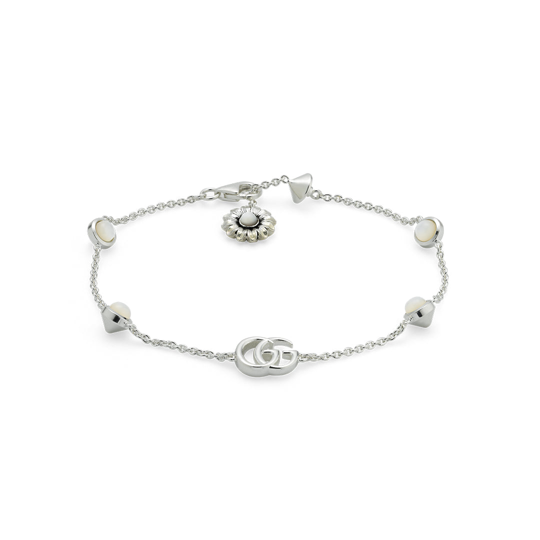 The Gucci GG Marmont Sterling Silver Bracelet by GUCCI Fine Jewellery features a stylish geometric design with interlocking Double Gs and a round flower charm adorned with mother-of-pearl details.