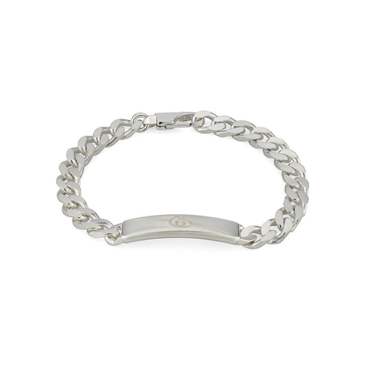 The Gucci Diagonal Interlocking G Sterling Silver Bracelet from GUCCI Fine Jewellery features a polished gourmette chain with a flat, rectangular plate showcasing an Interlocking G at its center. This bracelet is crafted from 925 sterling silver and includes a clasp closure for secure wear.