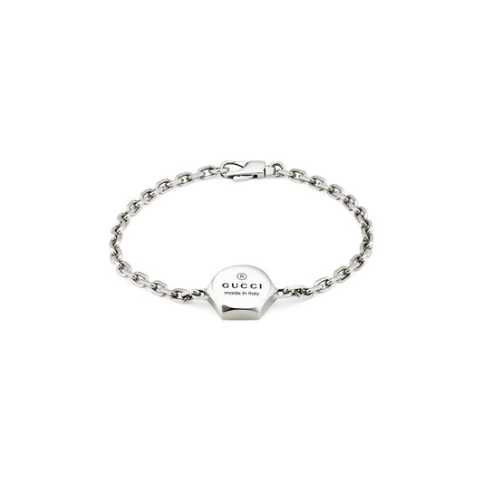 Introducing the Gucci Trademark Sterling Silver Bracelet by GUCCI Fine Jewellery: This exquisite piece showcases a sterling silver chain adorned with a hexagonal charm, expertly engraved with "GUCCI made in Italy." Secured with a clasp closure, this elegant bracelet effortlessly adds a touch of luxury to any ensemble.