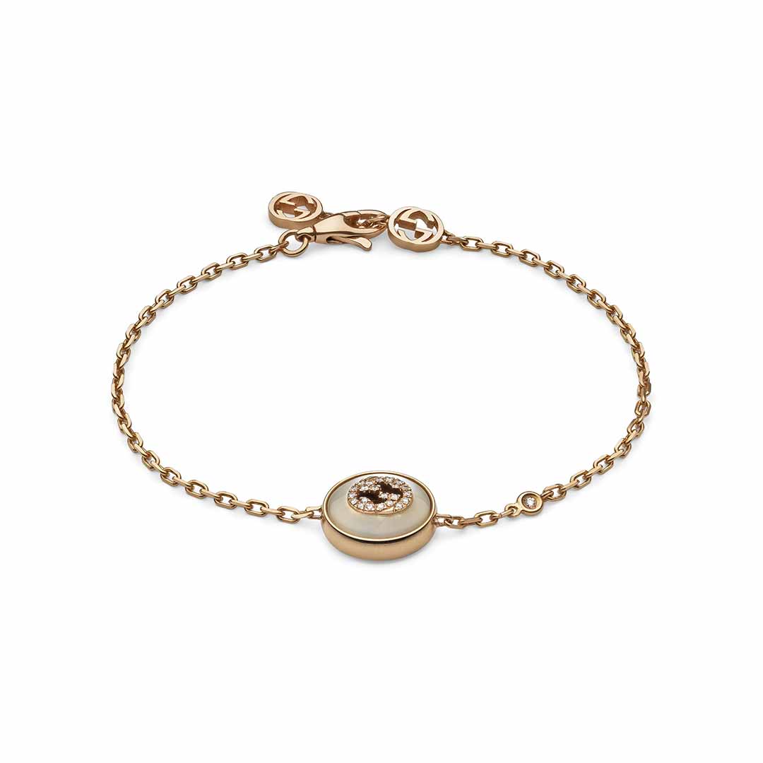 The Gucci Interlocking 18K Rose Gold Diamond Bracelet by GUCCI Fine Jewellery is an elegant and minimalistic piece featuring a central round pendant with a sparkling stone. The delicate rose gold bracelet includes a thin chain with a small logo charm near the clasp, embodying the sophistication of rose gold jewelry.