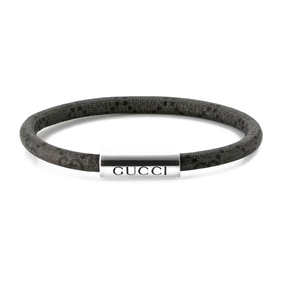 A round bracelet by GUCCI Fine Jewellery, featuring a dark textured design and a sterling silver clasp engraved with "GUCCI", from their Gucci Trademark GG Canvas collection.