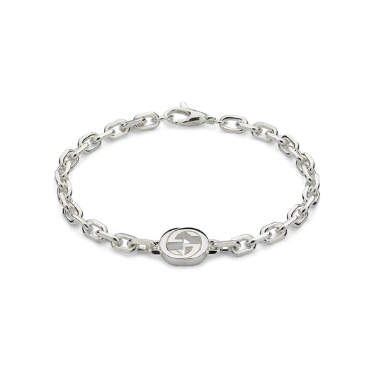 The Gucci Interlocking G Sterling Silver Bracelet by GUCCI Fine Jewellery is crafted in 925 sterling silver, featuring chain links with a circular emblem and interlocking G charm at the center, complete with a clasp fastening.