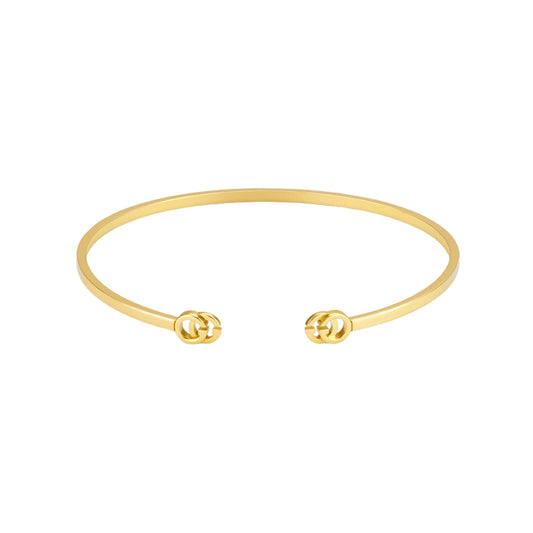 The Gucci GG Running 18K Yellow Gold Cuff by GUCCI Fine Jewellery features a minimalist open design with interlocking double G logos at each end, crafted with responsible jewelry practices.