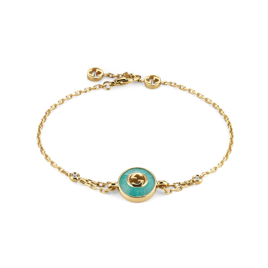 The Gucci Interlocking 18K Yellow Gold Diamond Bracelet with Amazonite by GUCCI Fine Jewellery features a round amazonite center, diamond accents, GG logos, and an adjustable clasp.