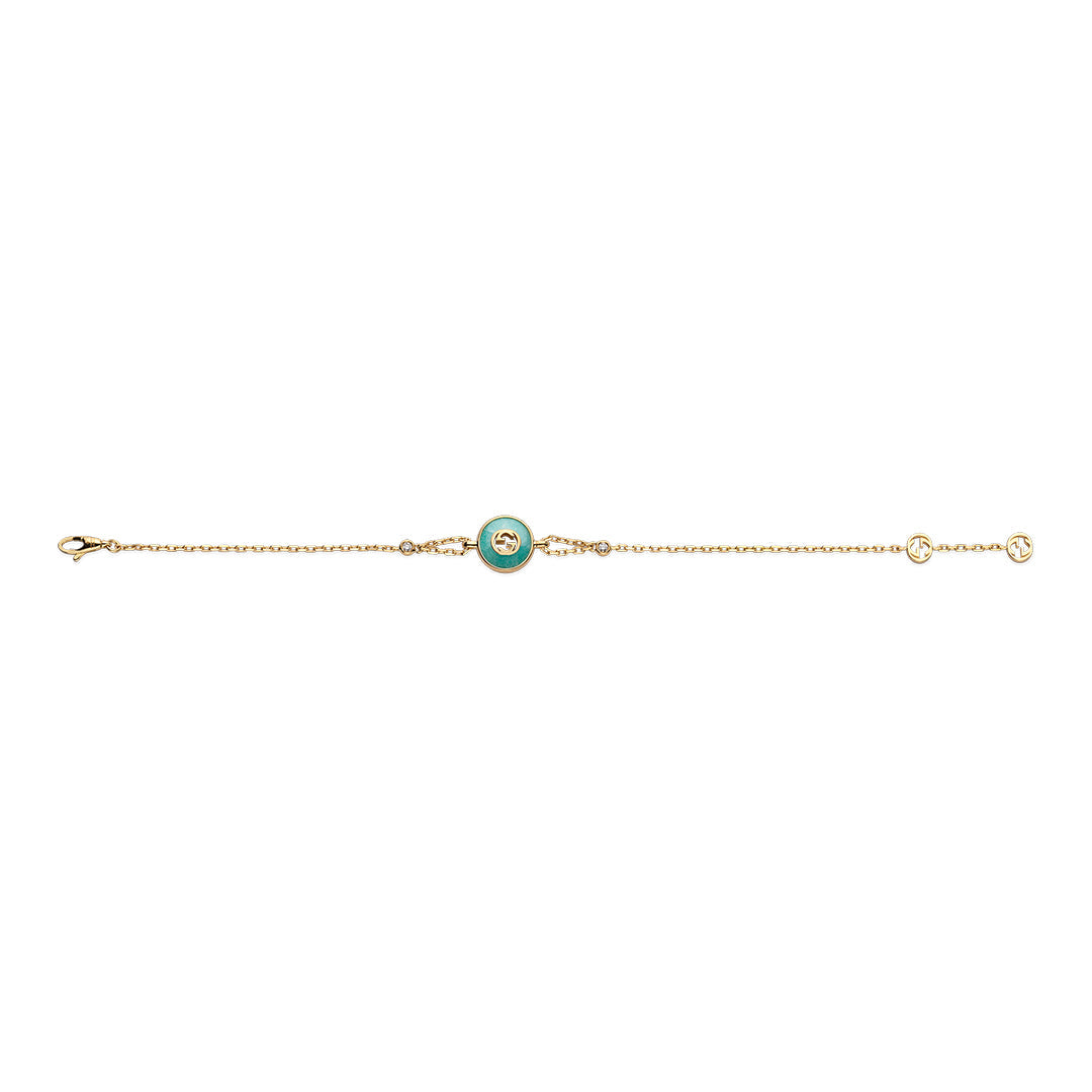 The Gucci Interlocking 18K Yellow Gold Diamond Bracelet with Amazonite by GUCCI Fine Jewellery features a circular green amazonite charm and diamond accents on a delicate chain, displayed on a white background.