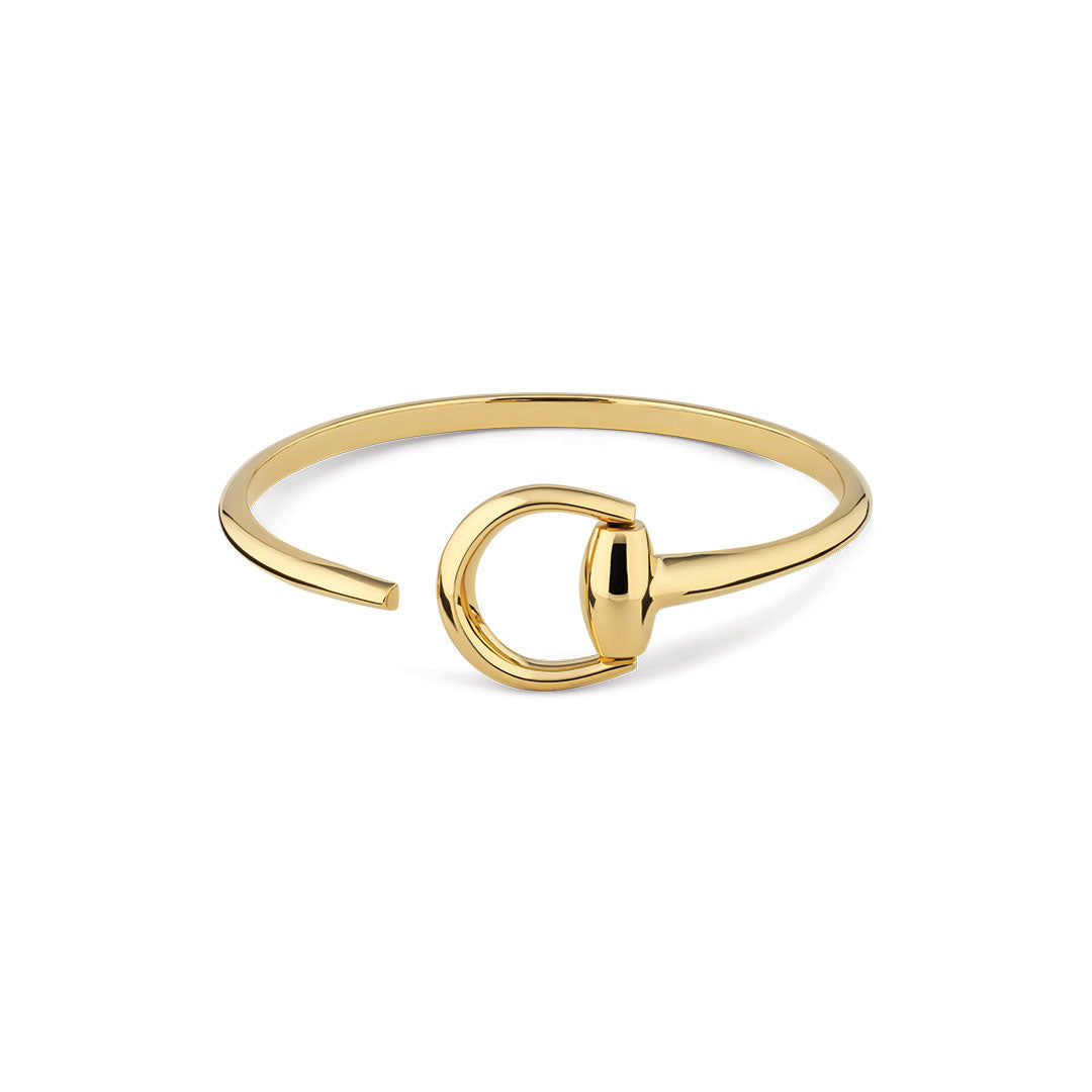 The Gucci Horsebit 18K Yellow Gold Cuff Bracelet by GUCCI Fine Jewellery features an open-ended, minimalist design with a signature circular Horsebit detail, shown on a white background.