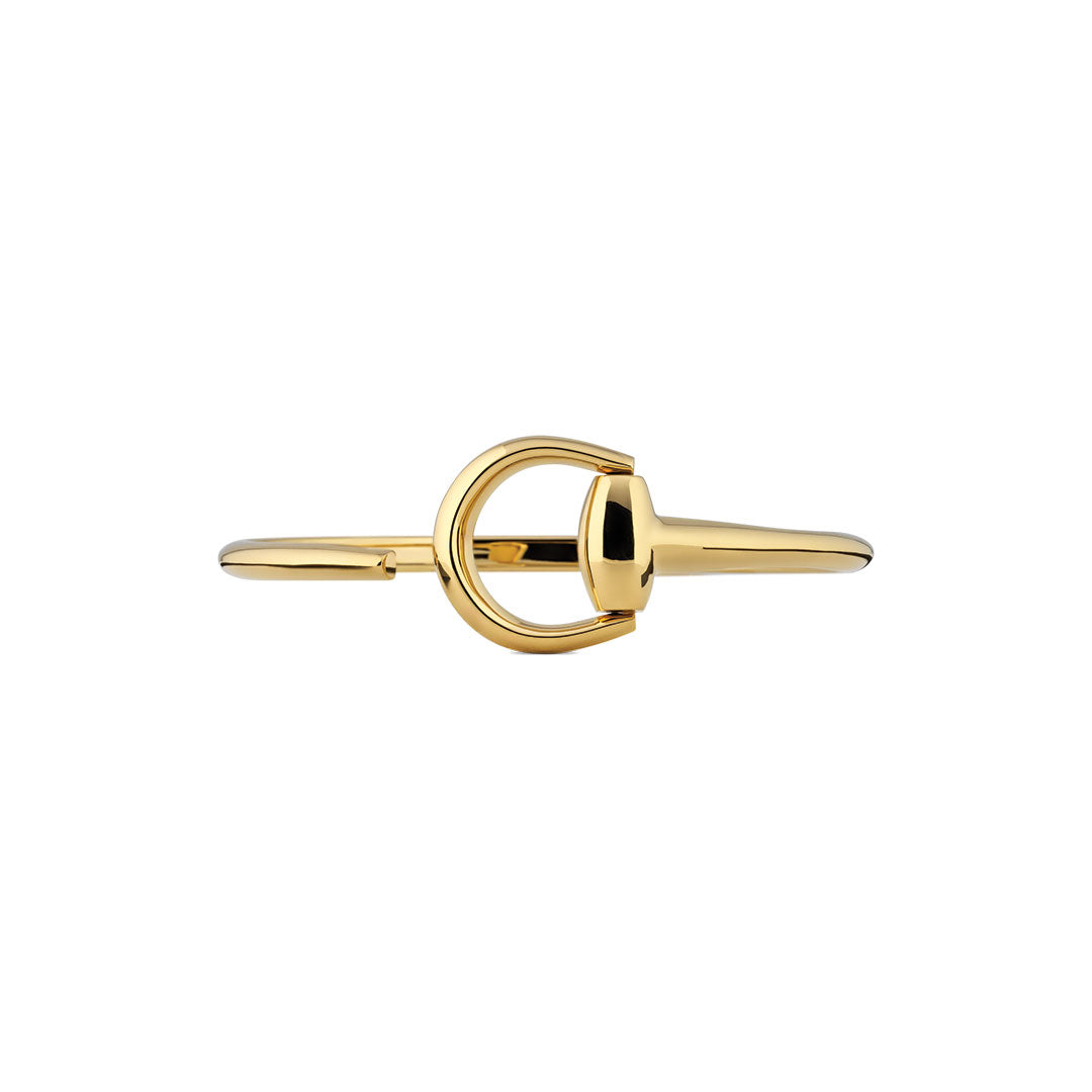 The Gucci Horsebit 18K Yellow Gold Cuff Bracelet by GUCCI Fine Jewellery features a central horseshoe-inspired clasp, crafted in polished gold and elegantly presented against a white background.