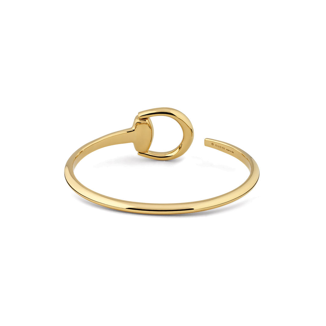 The Gucci Horsebit 18K Yellow Gold Cuff Bracelet by GUCCI Fine Jewellery features a minimalist design with a D-shaped clasp and polished finish, elegantly displayed on a white background.