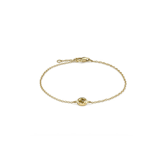 The Gucci Interlocking 18K Yellow Gold Chain Bracelet by GUCCI Fine Jewellery features a fine chain, a small circular Interlocking G charm, and a secure lobster clasp.