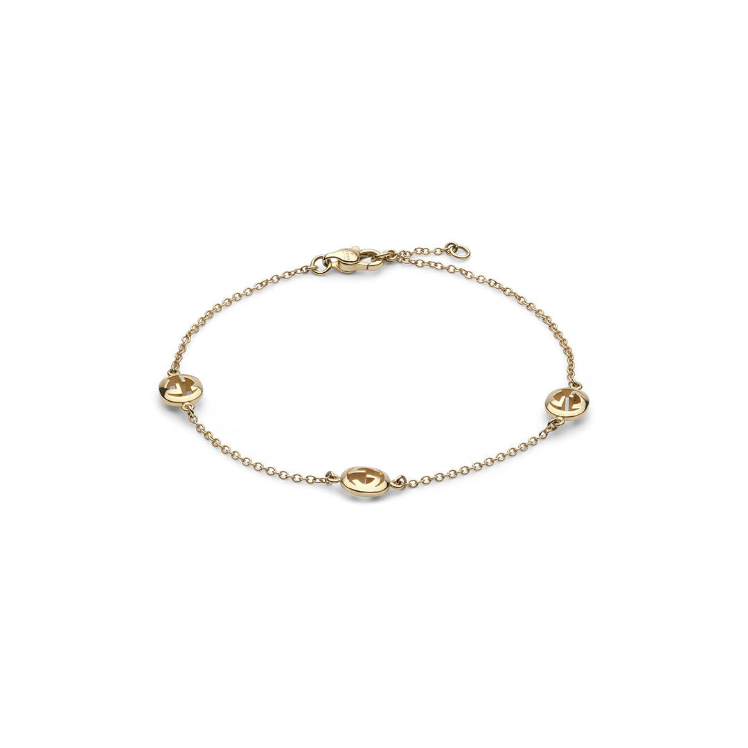 The Gucci Interlocking 18K Yellow Chain Bracelet by GUCCI Fine Jewellery features four evenly spaced round anchor cut-out charms and a lobster clasp, crafted in Italy from delicate yellow gold.