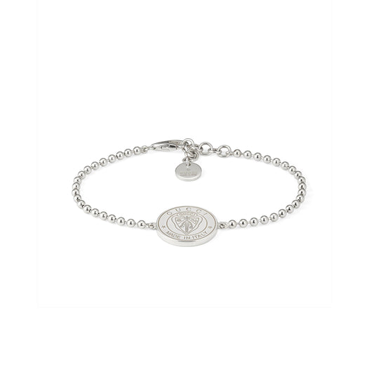 The Gucci Crest Sterling Silver Boule Bracelet by GUCCI Fine Jewellery features 925 sterling silver beads, a central engraved crest charm, and a small round tag near the clasp, all in a minimalist design. Displayed on a white background.
