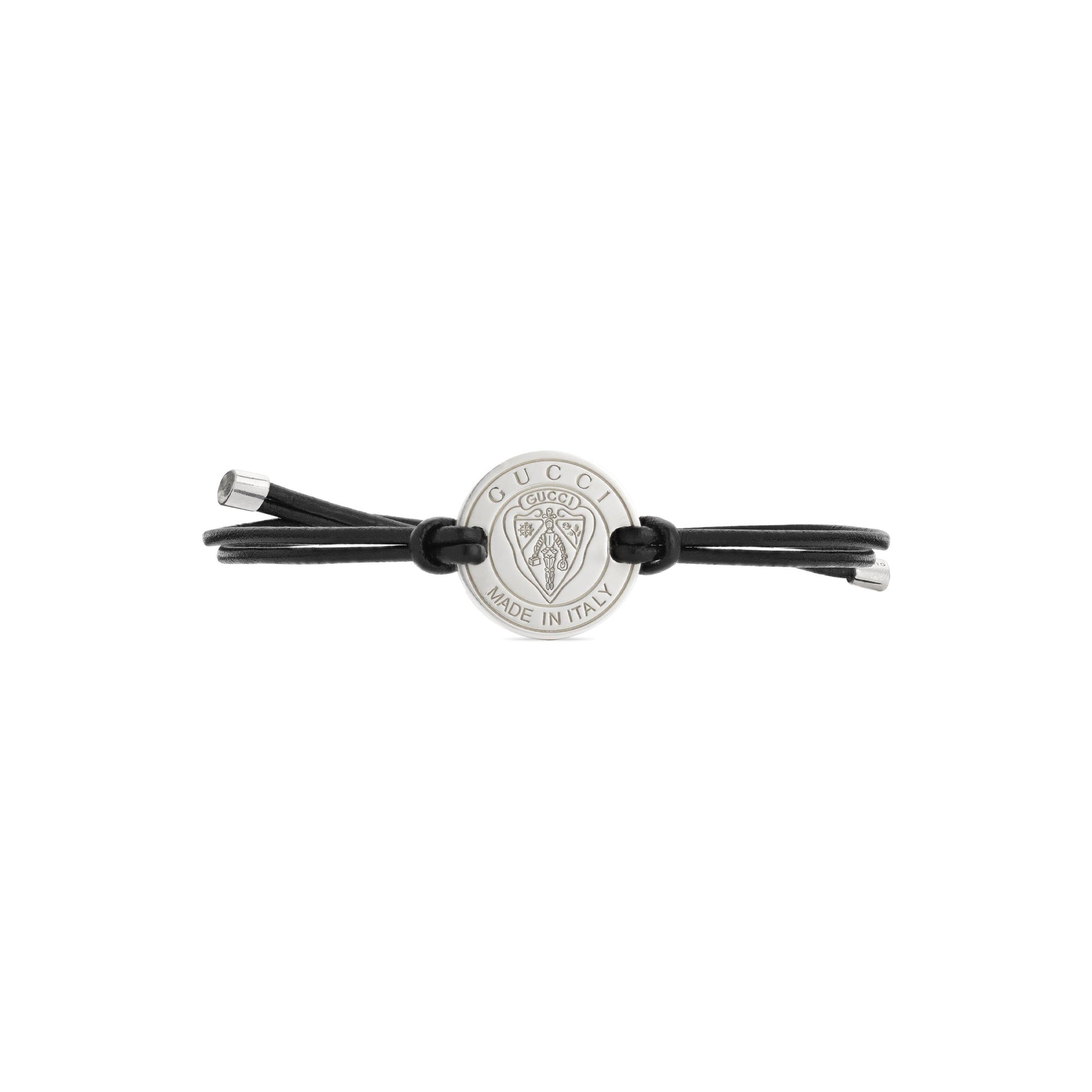 The GUCCI Fine Jewellery Crest Leather Cord with Sterling Silver Bracelet features a black leather cord, a round silver medallion engraved with the Gucci logo and "Made in Italy," plus two elegant sterling silver end caps.