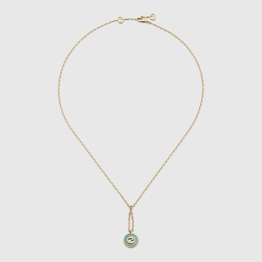 The Gucci Interlocking 18K Yellow Gold Diamond Necklace Pendant with Amazonite by GUCCI Fine Jewellery features a fine chain, a round pendant bordered in green amazonite, and a small central motif, shown on a plain white background.