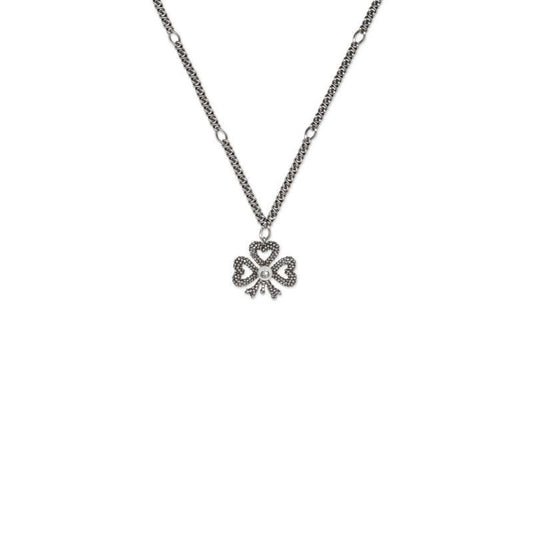 The Gucci Clover Sterling Silver Necklace Pendant from GUCCI Fine Jewellery showcases a clover-shaped pendant embellished with small stones. The design features three heart-shaped leaves, while the chain, highlighted by circular links, reflects Gucci's iconic elegance against a plain white background.