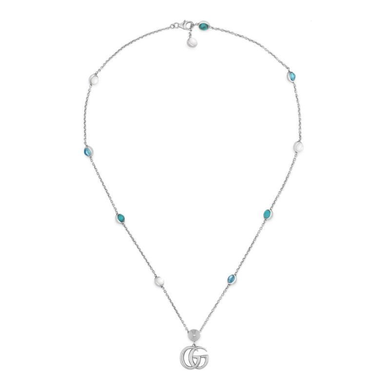 This sterling silver necklace from GUCCI Fine Jewellery features a pendant adorned with the iconic Double G design, enhanced by the lustrous mother of pearl. The chain is elegantly embellished with beads made of blue topaz and turquoise resin.