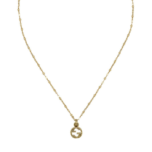 The GUCCI Fine Jewellery Interlocking G 18K Yellow Gold Necklace Pendant features a delicate chain and an arabesque-style engraving on its circular pendant, showcasing the iconic Gucci Interlocking G design.