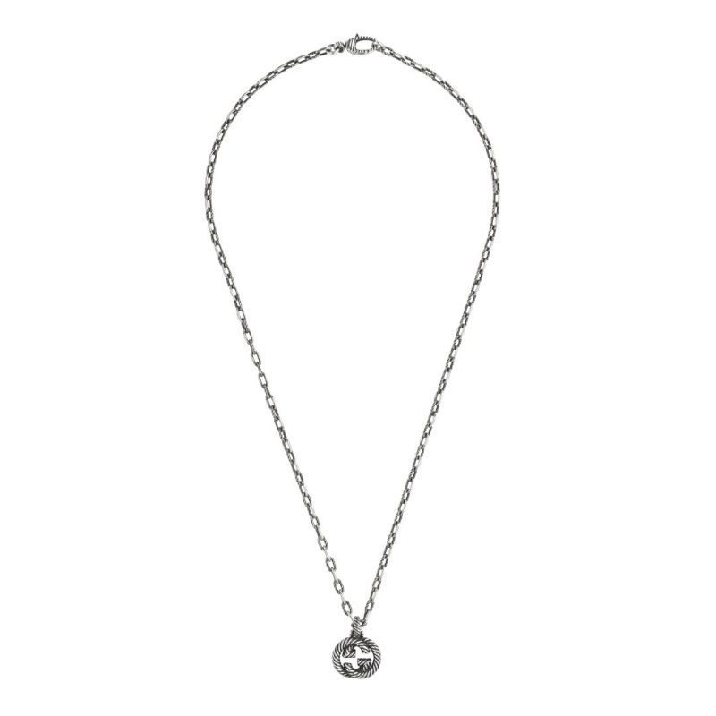 The Gucci Interlocking G Aged Sterling Silver Necklace Pendant by GUCCI Fine Jewellery features a small, detailed pendant with a vintage-look, adding an elegant touch to any outfit.