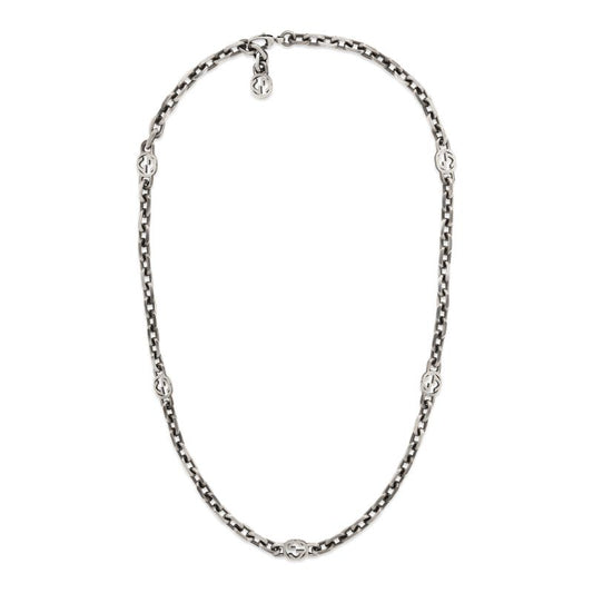 Introducing the Gucci Interlocking G Sterling Silver Station Necklace from GUCCI Fine Jewellery, showcasing a sleek silver chain adorned with small, evenly spaced circular emblems. This elegant piece is elegantly displayed in an oval shape against a plain white background, emphasizing its polished sterling silver links.