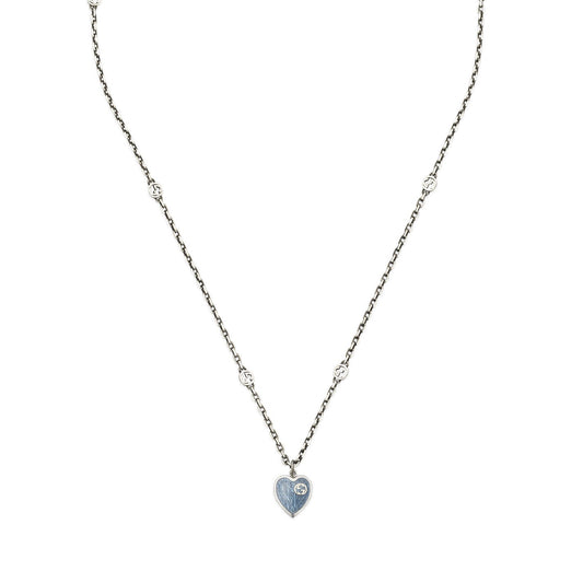 A sophisticated Gucci Interlocking G Sterling Steel Necklace from GUCCI Fine Jewellery, featuring a chain adorned with uniformly distributed small circular accents and an interlocking G heart-shaped pendant, elegantly enhanced with blue enamel on one side.