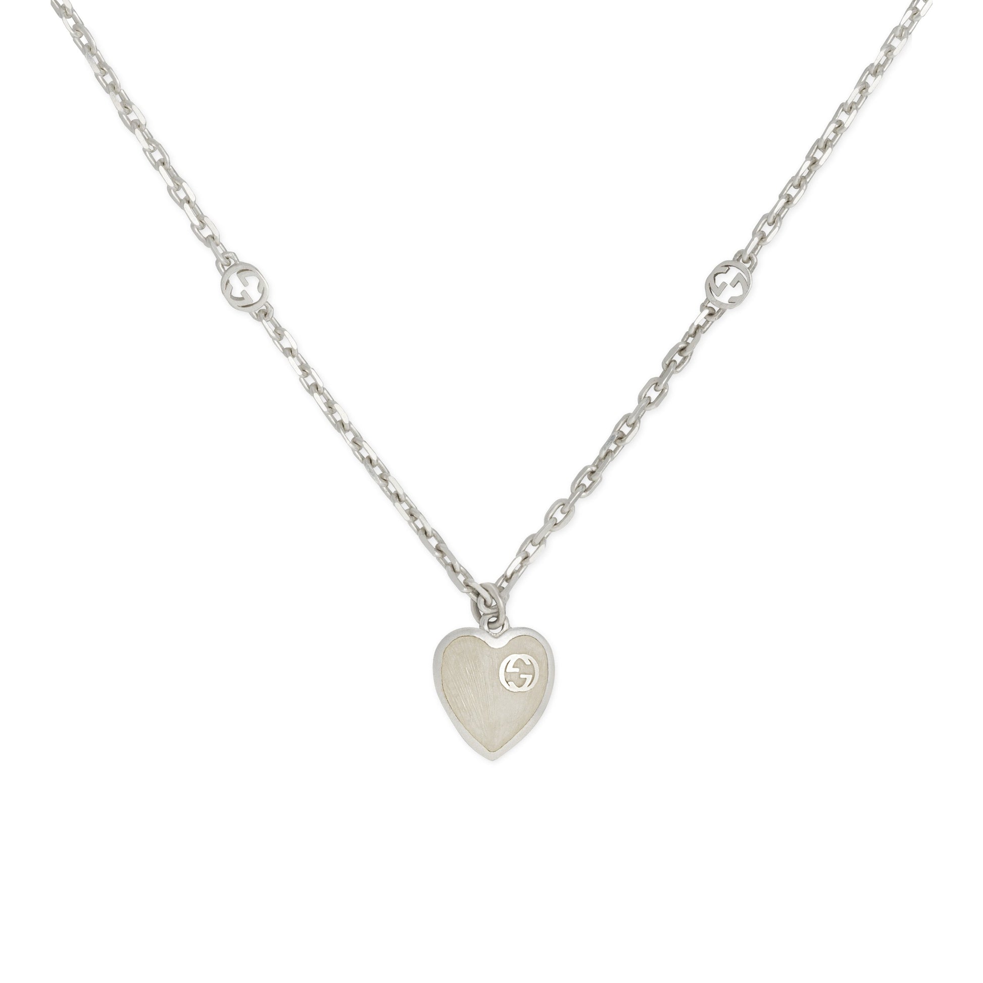 The Gucci Interlocking G Sterling Silver Heart Enamel Necklace by GUCCI Fine Jewellery features a delicate 925 sterling silver chain with circular accents and a heart-shaped pendant adorned with mother of pearl effect enamel.