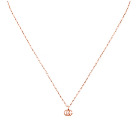 An elegant 18K rose gold necklace from GUCCI Fine Jewellery features a GG Running pendant with interlocking letters, complete with a delicate and minimalist chain that emphasizes its sophisticated design.