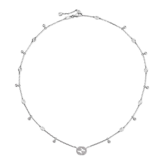 The Gucci Interlocking G 18K White Gold Diamond Station Necklace Pendant by GUCCI Fine Jewellery features small round diamonds along the chain and a central circular pendant adorned with additional diamonds.