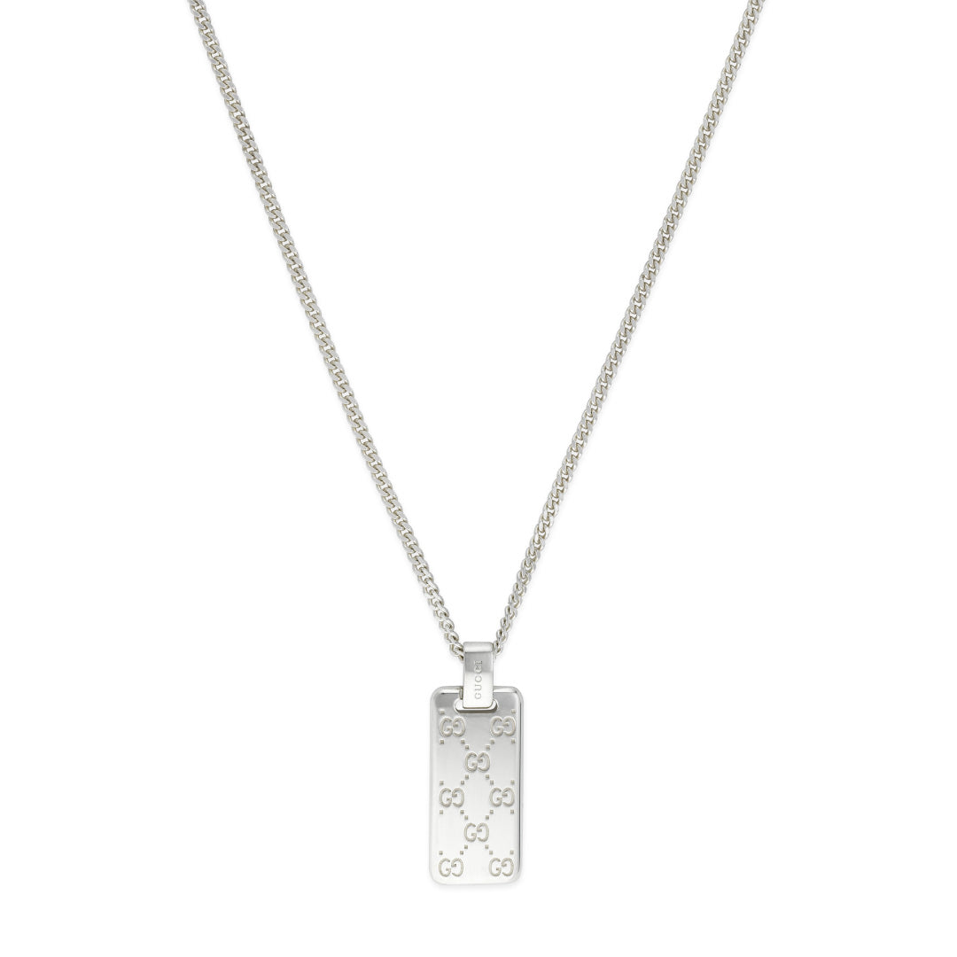The Gucci Signature Sterling Silver Necklace from GUCCI Fine Jewellery showcases a rectangular pendant adorned with the iconic GG tags, suspended from a delicate chain. The pendant's repeated design radiates a chic and sophisticated aesthetic.