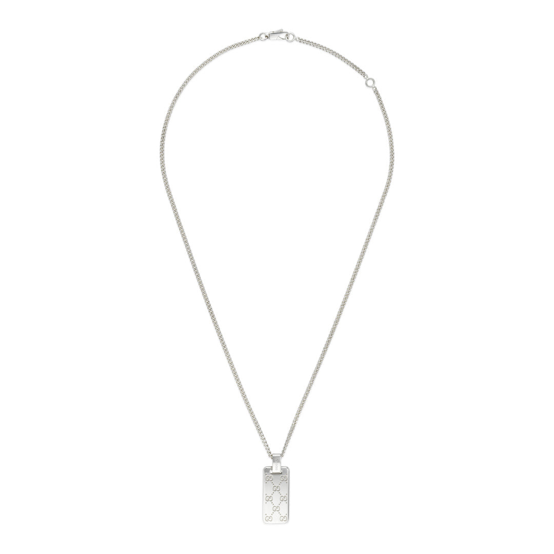 A necklace made from sterling silver features a rectangular pendant by GUCCI Fine Jewellery, embellished with engraved GG motif patterns and Gucci tags.
