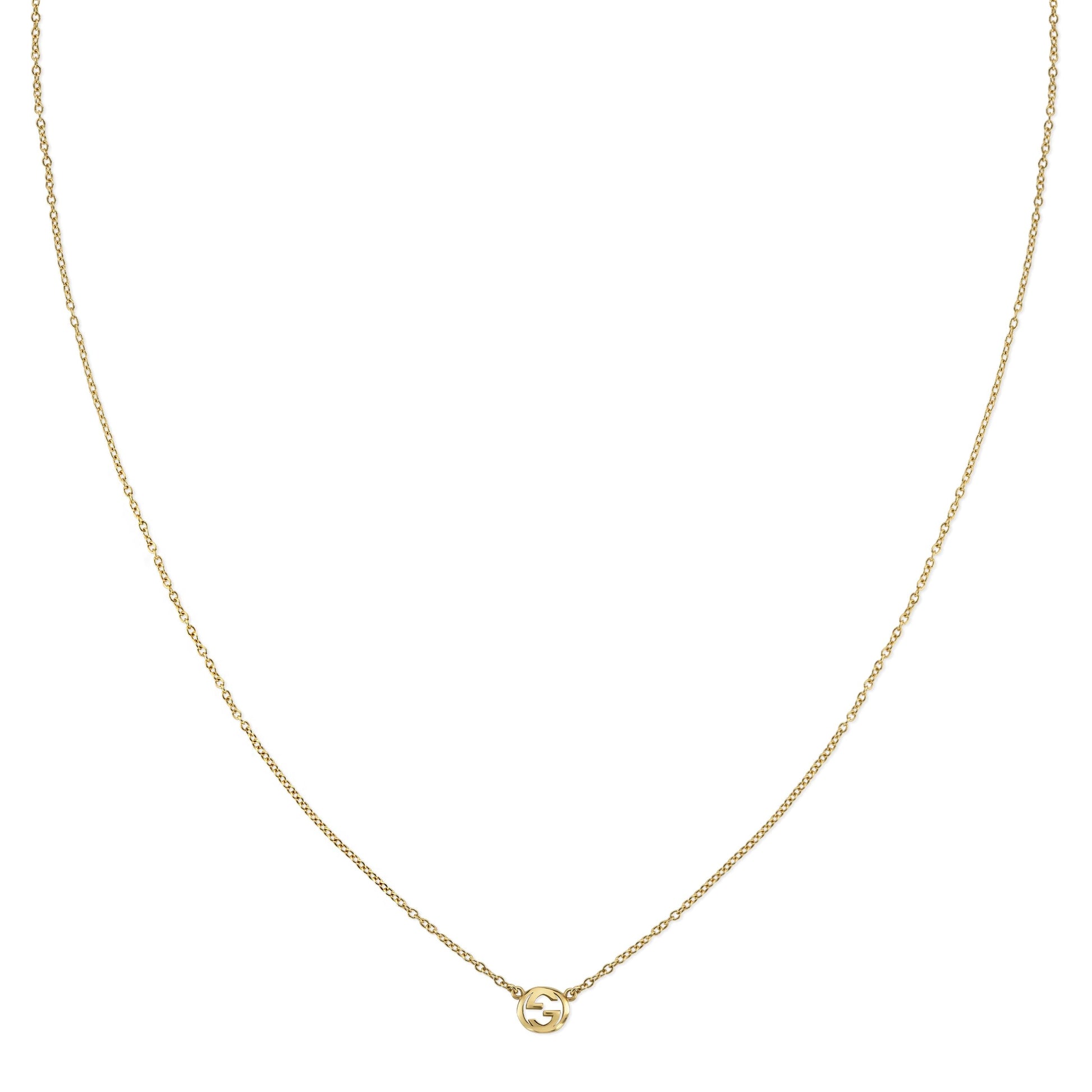 The Gucci Interlocking 18K Yellow Gold Necklace Pendant by GUCCI Fine Jewellery features a delicate yellow gold chain and a round pendant with the signature Interlocking G logo.