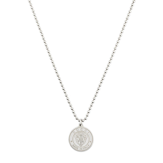 The Gucci Crest Sterling Silver Necklace Pendant by GUCCI Fine Jewellery features a round pendant engraved with a lion’s head and the signature crest, offering refined elegance on a white background.
