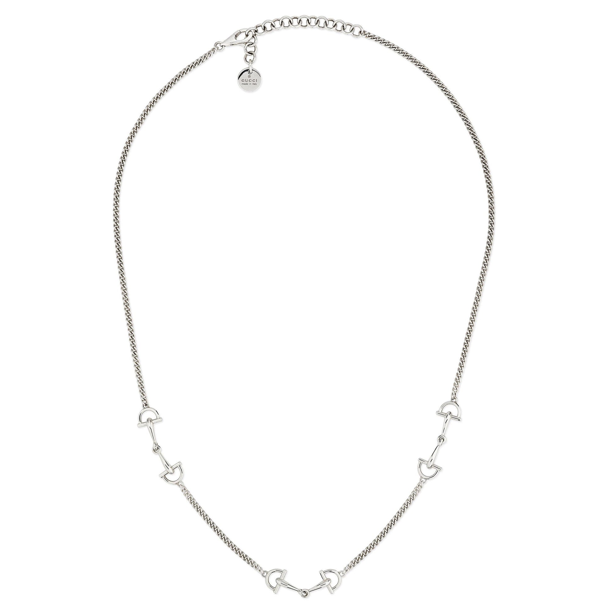 The Gucci Staffa Sterling Silver Station Necklace by GUCCI Fine Jewellery features small, evenly spaced horse bit-shaped charms and an adjustable clasp with a round tag, all crafted from sterling silver.