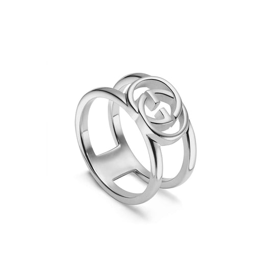 This Gucci Interlocking G Wide Open Band Sterling Silver Ring from GUCCI Fine Jewellery showcases a unique circular pattern with an interlocking G design on the band. The white background accentuates its shiny and polished finish, enhancing the elegance of this exquisite piece.