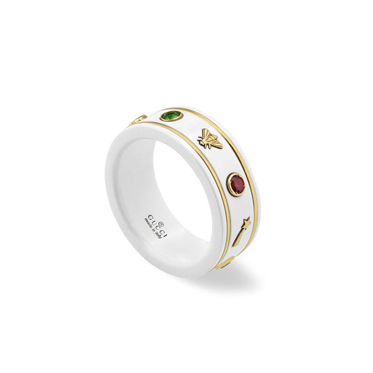 This Gucci Icon White Zarconia Ring by GUCCI Fine Jewellery is adorned in 18K yellow gold, featuring a bee motif, multi-colored gemstones including green and red ovals, and arrow designs. The inner band displays the signature Gucci logo and hallmark.