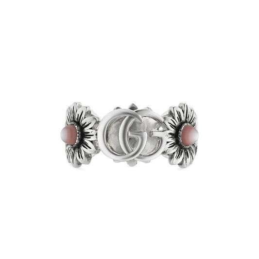 This Gucci Double G Sterling Silver Ring With Pink Mother Of Pearl by GUCCI Fine Jewellery boasts intricate floral details with pink centers and an ornate double "G" monogram, exuding elegance and style.