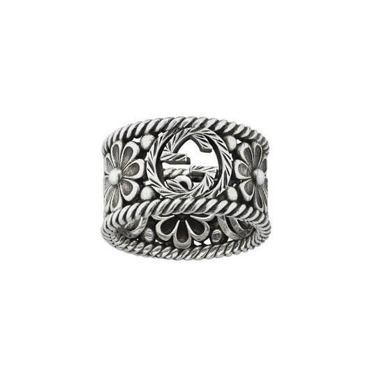 Intricately crafted, the Gucci Interlocking G Sterling Silver Ring by GUCCI Fine Jewellery features a detailed floral and braided rope design with a circular cut-out center. The wide band showcases symmetrical flower motifs and twisted rope elements, embodying Gucci's refined elegance.
