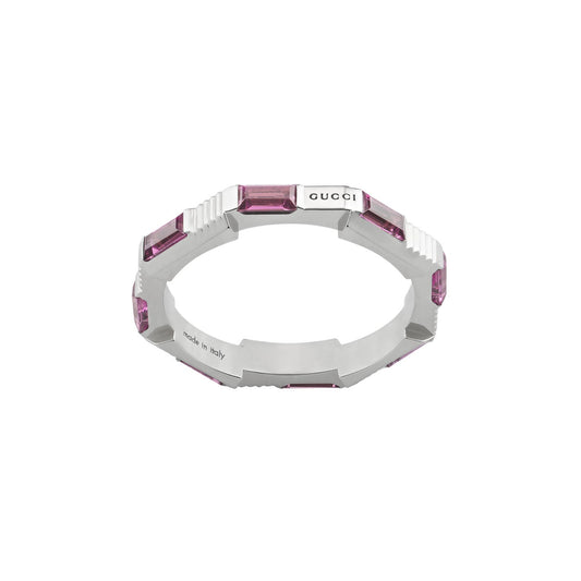 A silver bracelet with a geometric design featuring rectangular purple gemstones exudes elegance similar to the GUCCI Fine Jewellery collection. The polished metal finish, engraved with "GUCCI," reflects luxury, much like the Gucci Link to Love Rubellite 18K White Gold Ring adorned with pink rubellite.