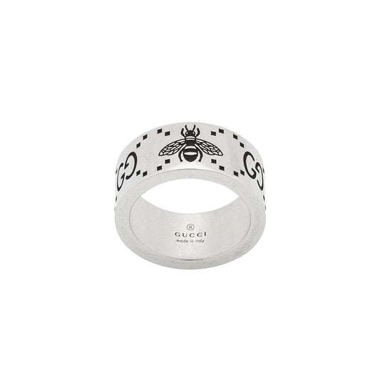 The Gucci GG And Bee Engraved Wide Sterling Silver Ring from GUCCI Fine Jewellery showcases a bee design surrounded by the GG motif, with "Made in Italy" inscribed inside. Its thick band and minimalist style make it a sophisticated addition to any jewelry collection.