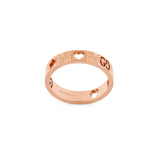 The Gucci Icon Heart 18K Rose Gold Ring, part of the GUCCI Fine Jewellery collection, showcases heart shapes intertwined with the iconic GG motif. The band is elegantly engraved with the Gucci logo and features a textured design complemented by a polished finish, all set against a plain white background.