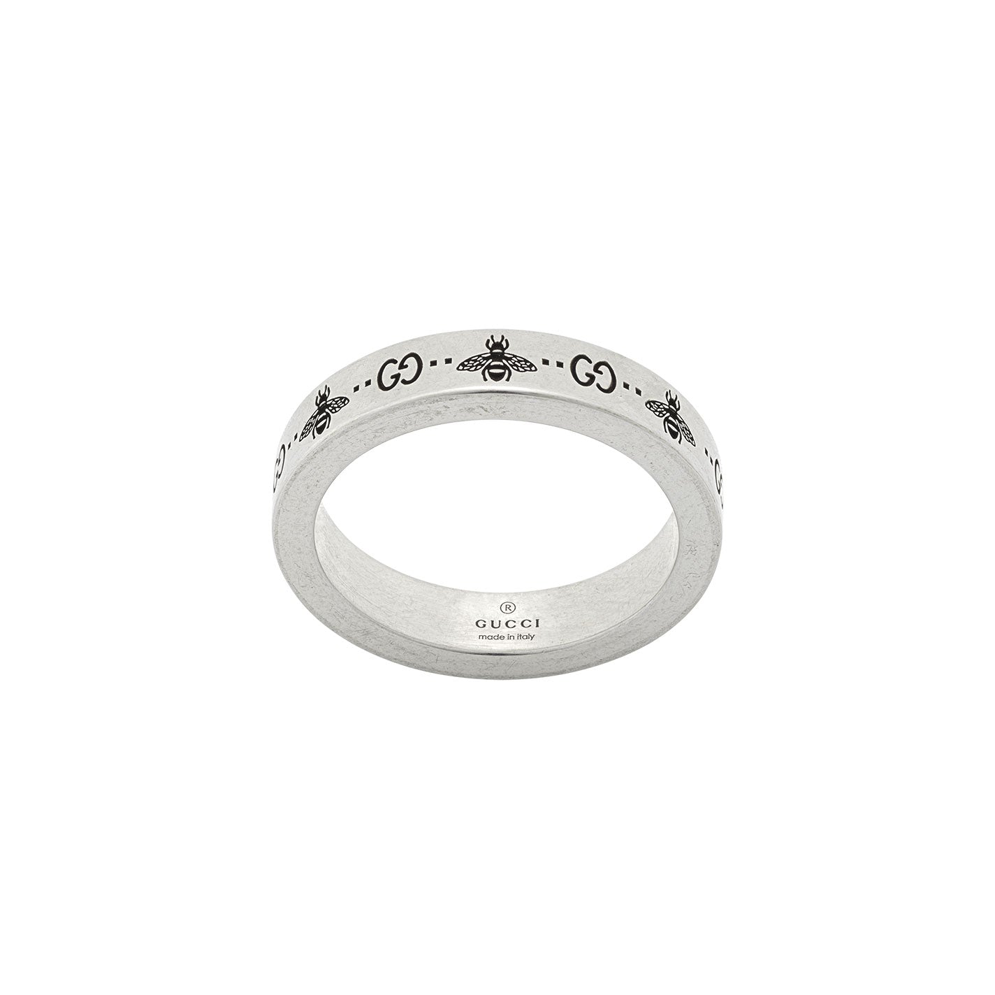 The Gucci GG and Bee Engraved Thin Sterling Silver Ring from GUCCI Fine Jewellery showcases the iconic "GG" letters alongside intricate bee motifs, with "GUCCI" and "Made in Italy" stamped on the interior.