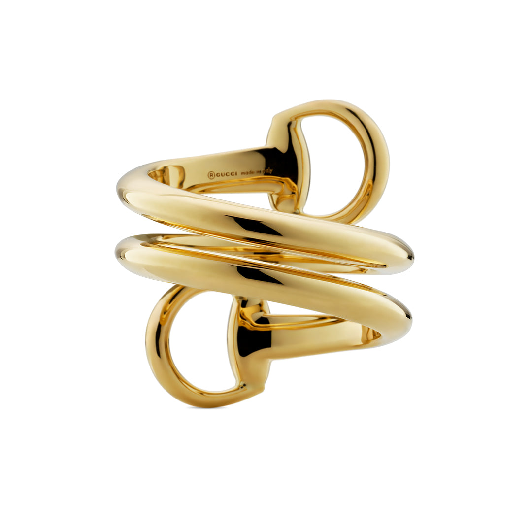 A sculptural GUCCI Fine Jewellery Horsebit 18K Yellow Gold Contrarie Ring features three thick, interlocking spiral bands with a polished finish, shown against a white background.