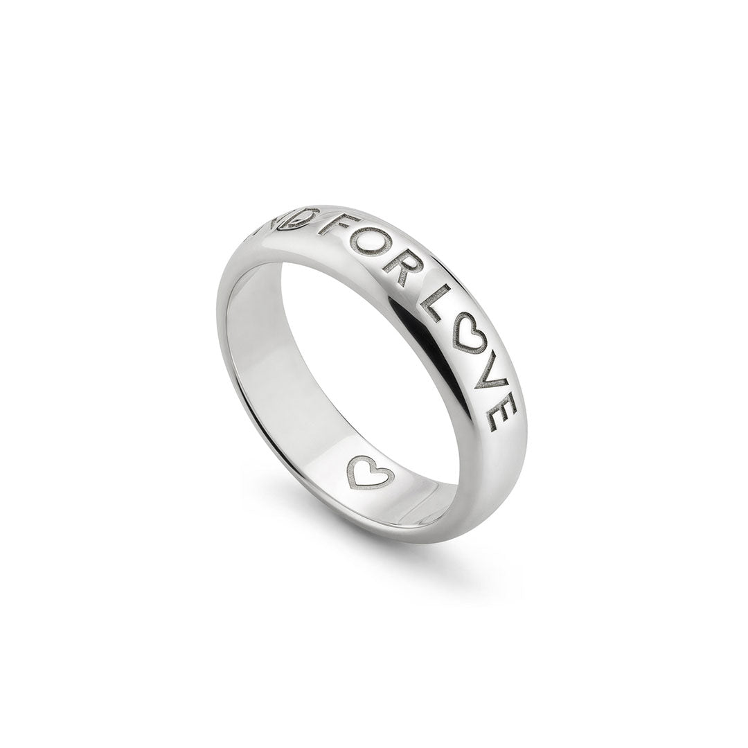 The Gucci Blind For Love 5mm Sterling Silver Ring by GUCCI Fine Jewellery features "FOR LOVE" and heart motifs engraved on the outer band, inspired by the phrase "Blind For Love," displayed on a white background.
