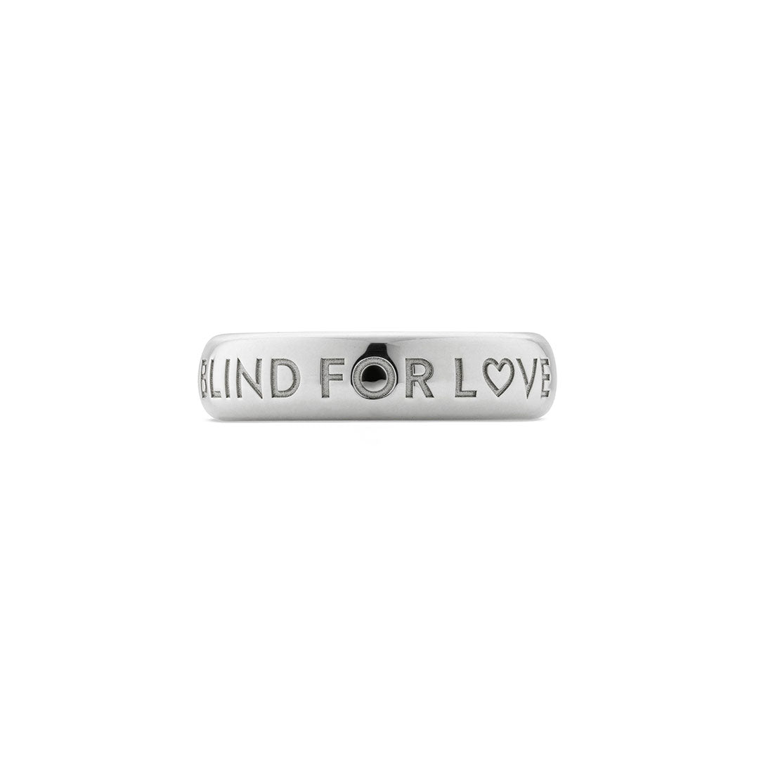 The Gucci Blind For Love 5mm Sterling Silver Ring by GUCCI Fine Jewellery features "BLIND FOR LOVE" engraved in uppercase with a heart symbol replacing the "O" in "LOVE.